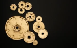 Metallic gears on dark background representing website & tech systems working together”